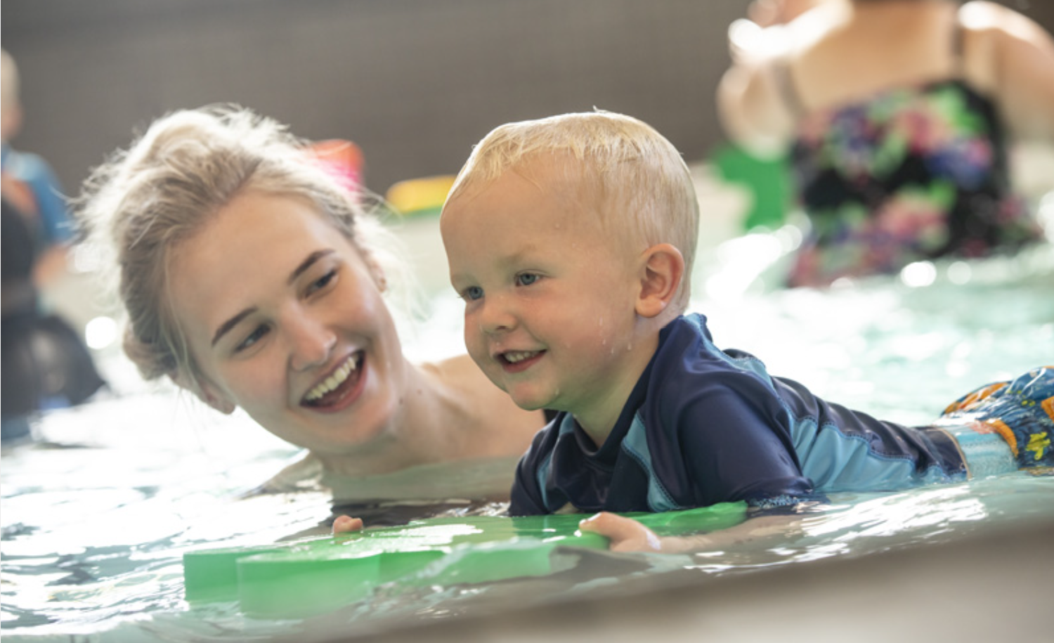 woman and child on bodyboard in pool