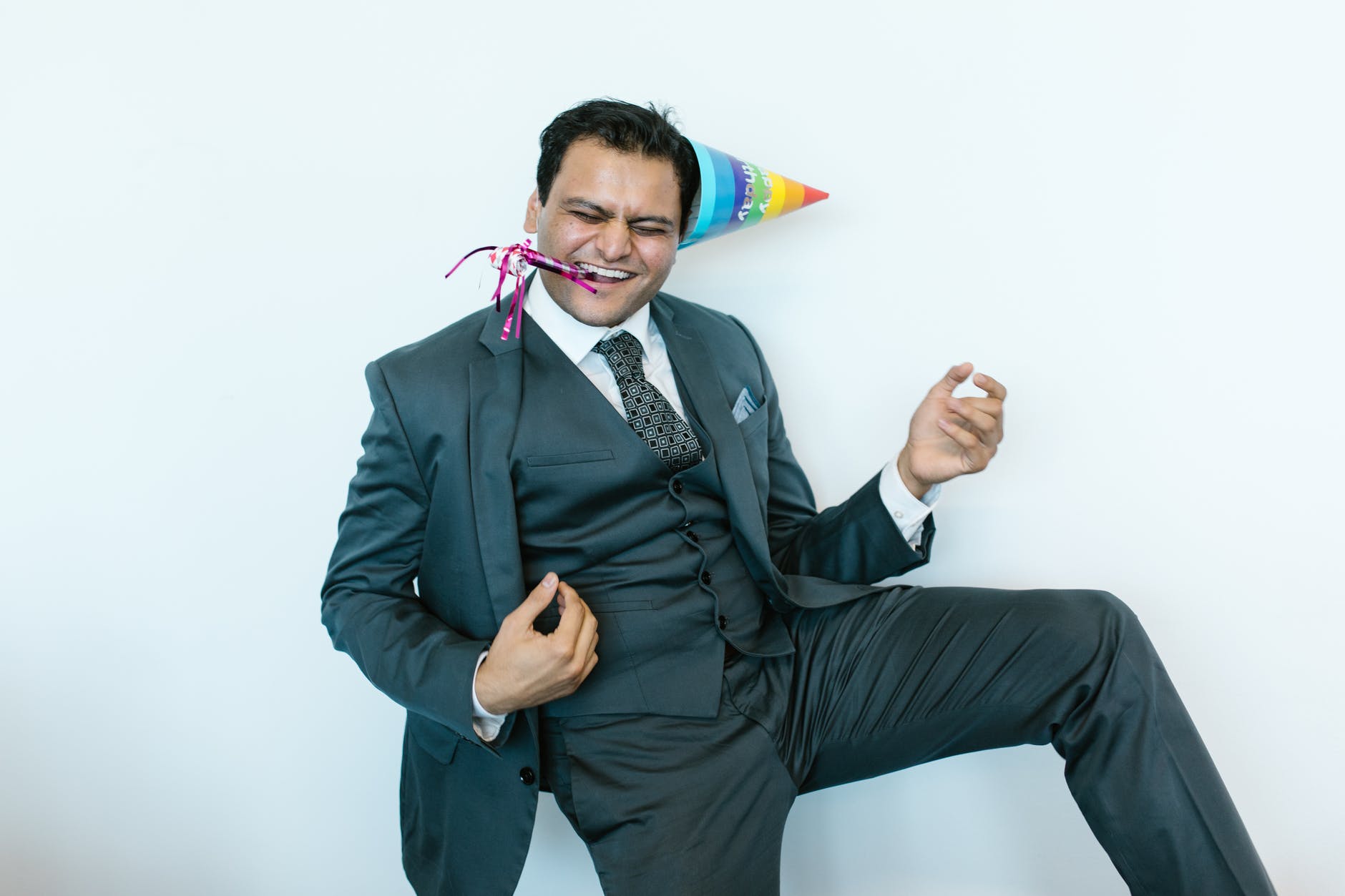 man in suit jacket wearing a party hat